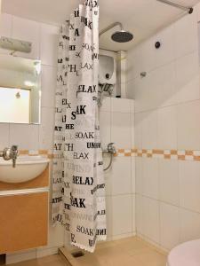 a bathroom with a shower curtain with writing on it at Wind Chimes Hideaway - Apartment In Central Hanoi in Hanoi