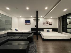 a living room with two beds and a couch at Nomad Apartment in Nha Trang