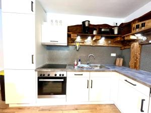 a kitchen with white cabinets and a sink at Ferienhaus Wiesenlandl in Bischofswiesen