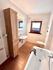 a bathroom with a tub and a sink and a toilet at Ferienhaus Wiesenlandl in Bischofswiesen