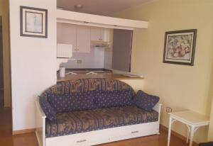 a couch in a living room with a kitchen at Las Americas beach apartment in Playa de las Americas