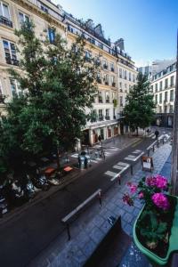 - une vue sur une rue de la ville avec des bâtiments et des fleurs dans l'établissement Paris City Flat App entier N106 F3, à Paris