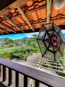 une lampe suspendue sur un balcon avec vue dans l'établissement Suítes The Search Ubatuba Surf - Maranduba, à Ubatuba