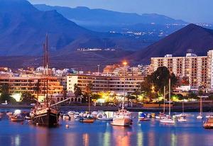 a group of boats in a harbor with a city at Vv Los Cristianos centre in Los Cristianos