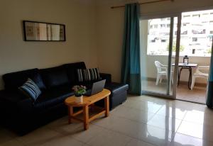 a living room with a couch and a table with a laptop at Vv Los Cristianos centre in Los Cristianos
