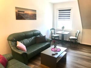 a living room with a leather couch and a table at Apartment Enno in Auerbach