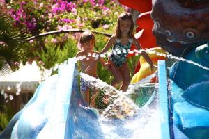 two young children playing on a water slide at Iberostar Ciudad Blanca in Port d'Alcudia