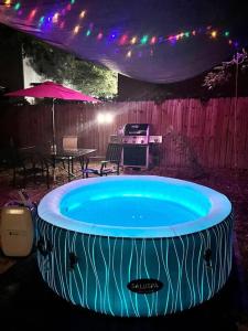 a large hot tub in a yard with a table at Belair Lux 3BR 3BA Home W Private Hot tub, 3k Arcade Games & private garage- 5mins to the Airport in San Antonio