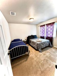 a bedroom with two beds and a table in it at Belair Lux 3BR 3BA Home W Private Hot tub, 3k Arcade Games & private garage- 5mins to the Airport in San Antonio