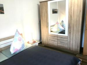 a bedroom with a bed with a mirror and a dresser at Apartment Enno in Auerbach