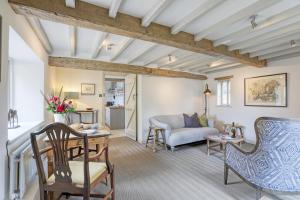 a living room with a couch and a table at Ostlers Loft in Chipping Campden