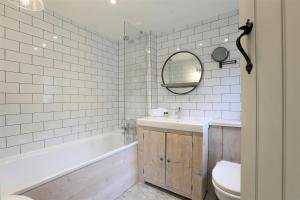 a bathroom with a tub and a sink and a toilet at Ostlers Loft in Chipping Campden