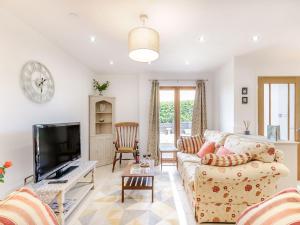 a living room with a couch and a tv at The Ark Barn in Chillenden