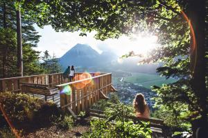 Dos personas sentadas en bancos mirando una montaña en Vitalhotel Kaiserhof, en Seefeld in Tirol