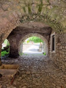 une arche dans un mur en pierre avec une route dans l'établissement PietraViva Casa vacanze FAICCHIO, NON VISANTI, à Visanti