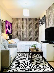 Comfy Double bedroom with a Private Toilet في لندن: غرفة معيشة مع أريكة وتلفزيون