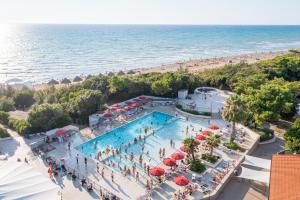 een uitzicht over een zwembad naast een strand bij Paradù EcoVillage & Resort in Marina di Castagneto Carducci