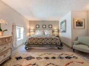 a bedroom with a bed and a chair at The Barn in Shipton under Wychwood