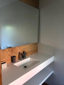 lavabo blanco en una habitación con pared en Apartamentos Montemar en Navia