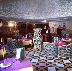 a restaurant with tables and chairs and a large vase at HOTEL AL MAMOUN in Casablanca