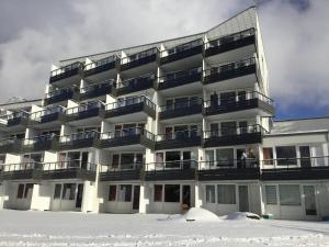 un edificio de apartamentos con nieve delante en FERIENWOHNUNG FORSTPANORAMA en Sankt Englmar