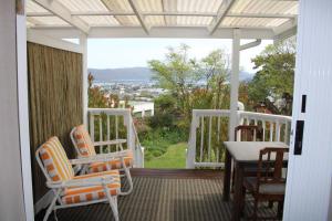 a porch with chairs and a table and a view at 14 Mount Joy in Knysna