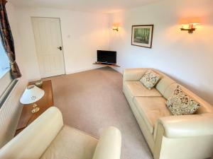 a living room with a couch and a tv at Willow Cottage in Ironbridge