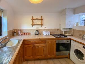 een keuken met een wastafel en een fornuis top oven bij Willow Cottage in Ironbridge