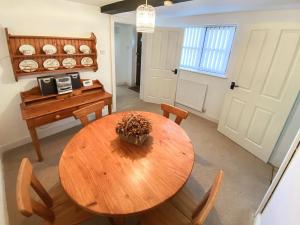 a dining room with a wooden table and chairs at Willow Cottage in Ironbridge