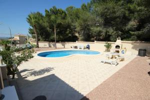 una piscina en un patio con sillas y árboles en Preciosa Villa con Piscina particular, en San Miguel de Salinas