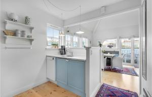 a kitchen with white walls and a blue island at Beautiful Apartment In Ringkbing With Sauna in Søndervig
