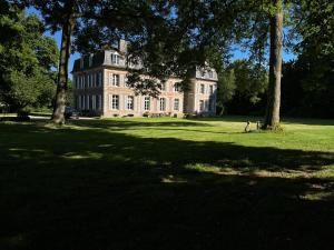 ein großes Haus inmitten eines Feldes mit Bäumen in der Unterkunft Chambres d'Aumont in Aumont