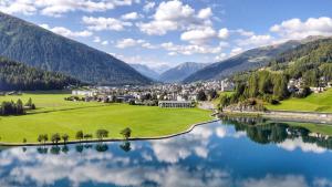 una città vicino a un corpo d'acqua con montagne di Hotel Terminus a Küblis