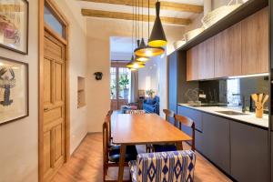 a kitchen and dining room with a wooden table and chairs at iloftmalaga Calle Álamos 23 in Málaga