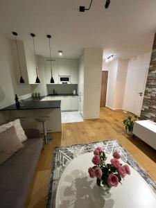 a living room with a table with flowers on it at Księżycowy Apartament Ursus in Warsaw