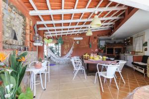 a kitchen and dining room with white chairs and a table at Guincho Garden Villa by Homing in Aldeia de Juso