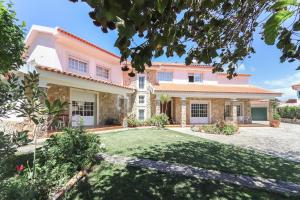 an exterior view of a house with a yard at Guincho Garden Villa by Homing in Aldeia de Juso