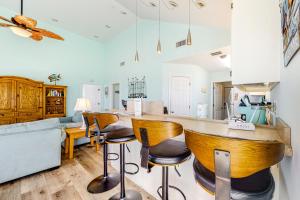 a kitchen with a bar with wooden stools at Sunset Beach in Dauphin Island