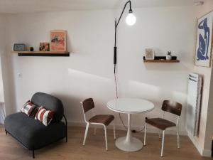 une table et des chaises dans une pièce avec une table et une chaise dans l'établissement Appartement '' L'Ossau '' hyper centre Place Clémenceau, à Pau