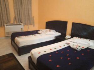 una habitación de hotel con 2 camas con adornos en New Panorama Resort, en El Fayum