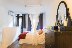 Dormitorio con cama con espejo y tocador en Villa Antolín, en El Molar