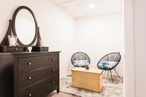 a bedroom with a dresser and two chairs and a mirror at Villa Antolín in El Molar