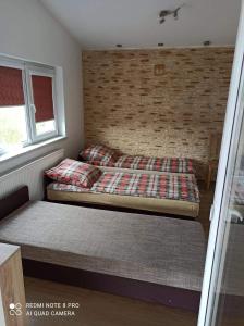 um quarto com 2 camas e uma parede de tijolos em Eko-Fish em Miastko