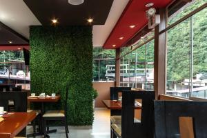 un ristorante con una parete verde con tavoli e sedie di Hotel Ferré Boulevard a Machu Picchu