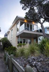 a house with a balcony on the side of it at Battery Cove Beach Front Apartment in Port Fairy