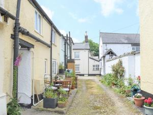 a street in a village with houses and plants at Teal Cottage in Honiton