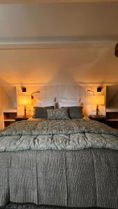 1 cama grande en un dormitorio con 2 lámparas en La Plonploniere, en Aix-en-Issart