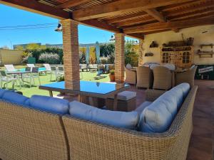un patio con muebles de mimbre, mesa y sillas en Casa Rural La Piedra De Juana, en Malpartida de Cáceres