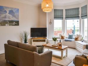 sala de estar con sofá y TV en The Sands, en Whitley Bay