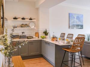 a kitchen with a counter and chairs in a room at The Sands in Whitley Bay